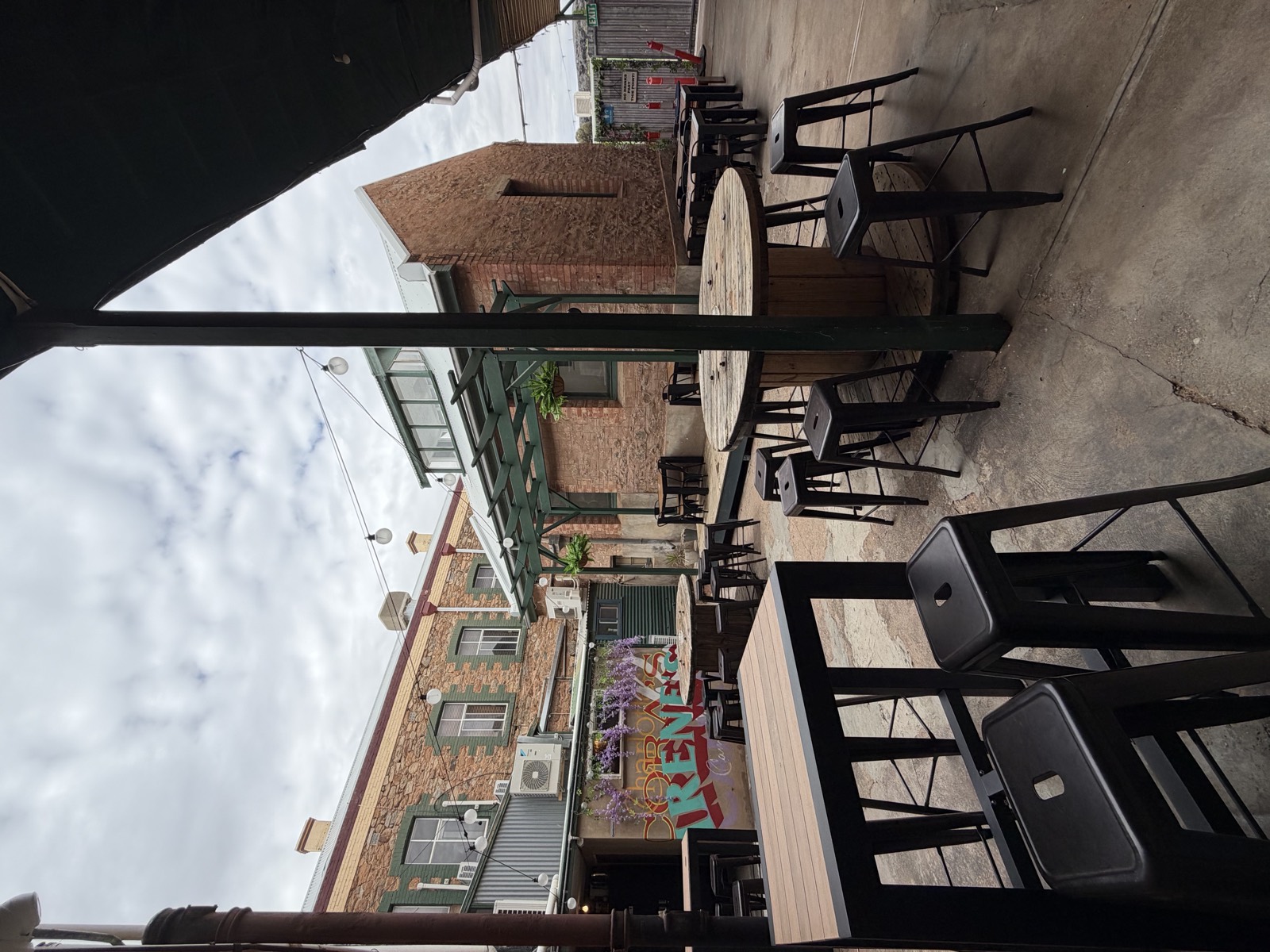 Mary's Bar courtyard with string lights, barrel tables and stools