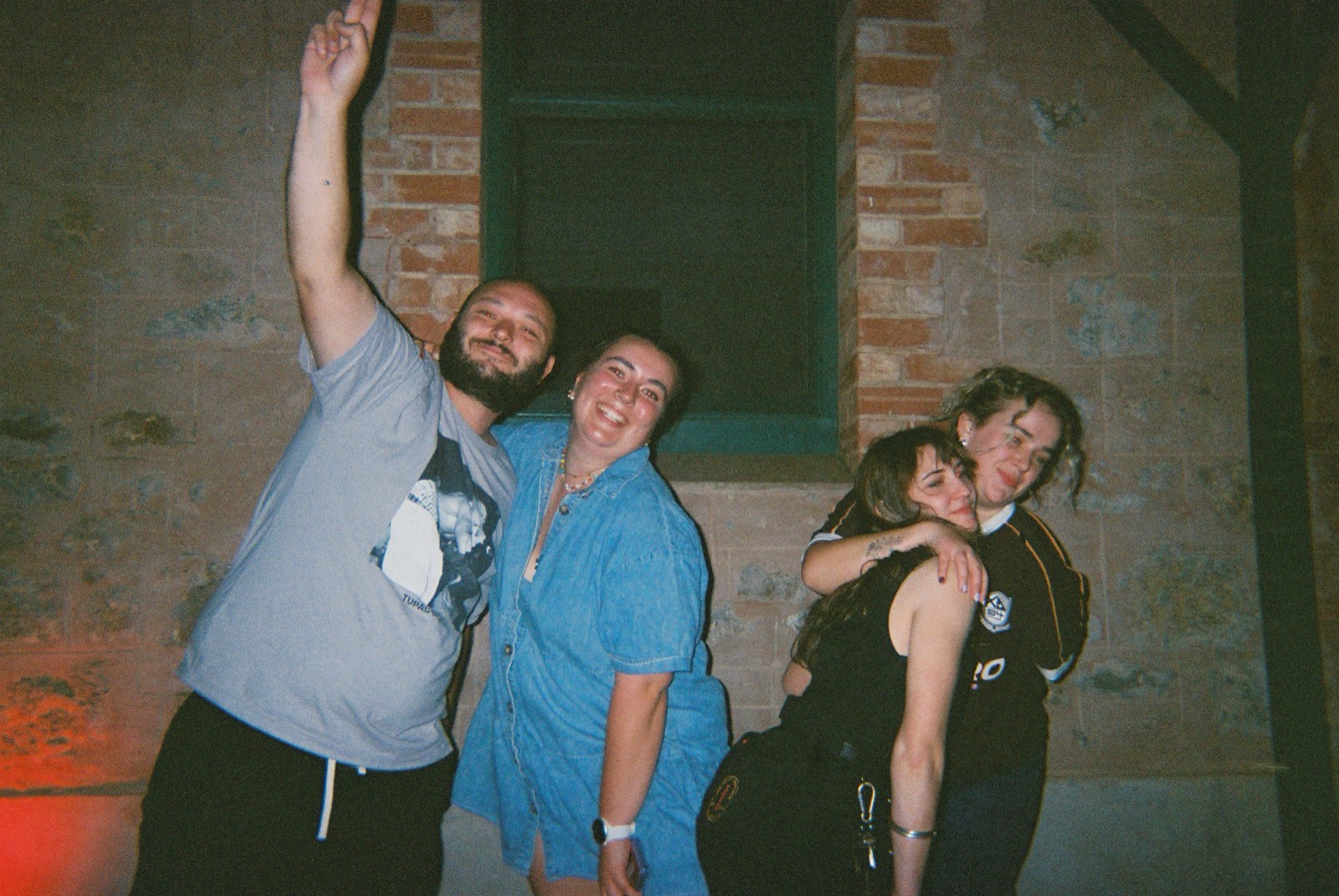 Mates posing for a photo against the brick wall at Mary's Bar